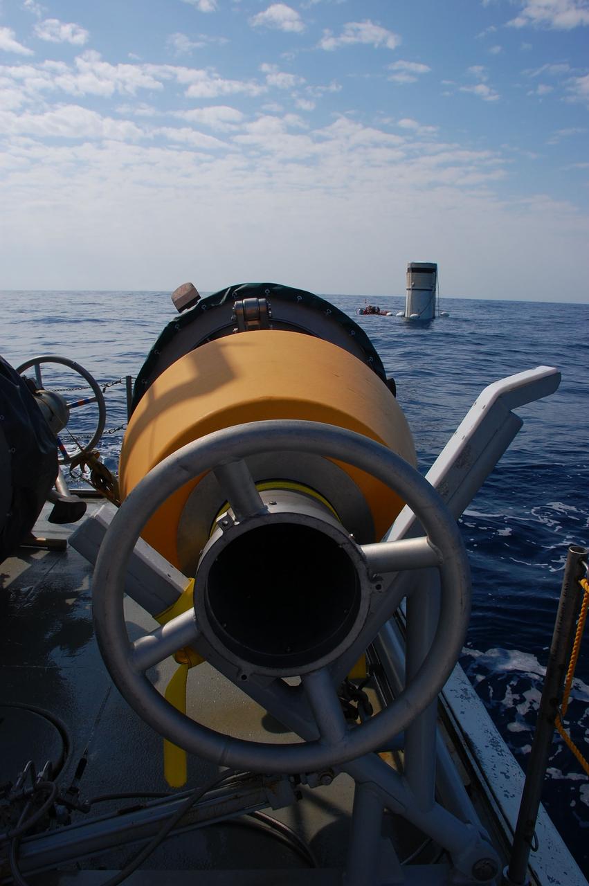 CAPE CANAVERAL, Fla. -- This image taken from the bow of Freedom Star, one of NASA's solid rocket booster retrieval ships, shows crew members in a skiff attaching flotation devices, or buoys, to the parachute lines from the left spent booster from space shuttle Discovery's STS-133 launch.        The shuttle’s two solid rocket booster casings and associated flight hardware are recovered in the Atlantic Ocean after every launch by Liberty Star and Freedom Star. The boosters impact the Atlantic about seven minutes after liftoff and the retrieval ships are stationed about 10 miles from the impact area at the time of splashdown. After the spent segments are processed, they will be transported to Utah, where they will be refurbished and stored, if needed. Photo credit: NASA/Ben Smegelsky