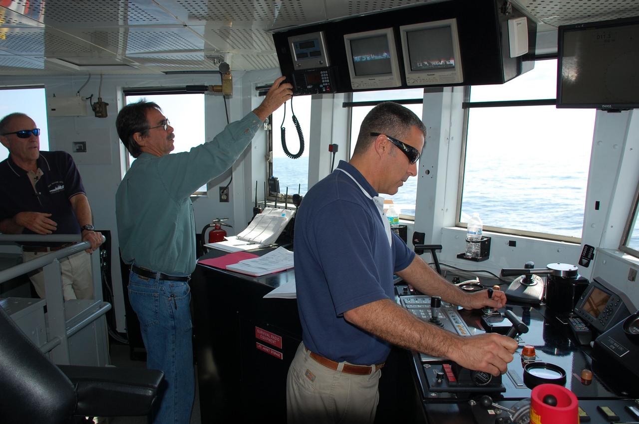 CAPE CANAVERAL, Fla. -- Captain Michael Nicholas mans the helm of Freedom Star, one of NASA's solid rocket booster retrieval ships, while John Fischbeck, Manager of Vessel Operations and Senior SRB Retrieval Supervisor, and Walt Adams, SRB Retrieval and Dive Supervisor, assist. The ship's crew members are recovering the left spent booster bobbing in the Atlantic Ocean from space shuttle Discovery's STS-133 launch.    The shuttle’s two solid rocket booster casings and associated flight hardware are recovered in the Atlantic Ocean after every launch by Liberty Star and Freedom Star. The boosters impact the Atlantic about seven minutes after liftoff and the retrieval ships are stationed about 10 miles from the impact area at the time of splashdown. After the spent segments are processed, they will be transported to Utah, where they will be refurbished and stored, if needed. Photo credit: NASA/Ben Smegelsky