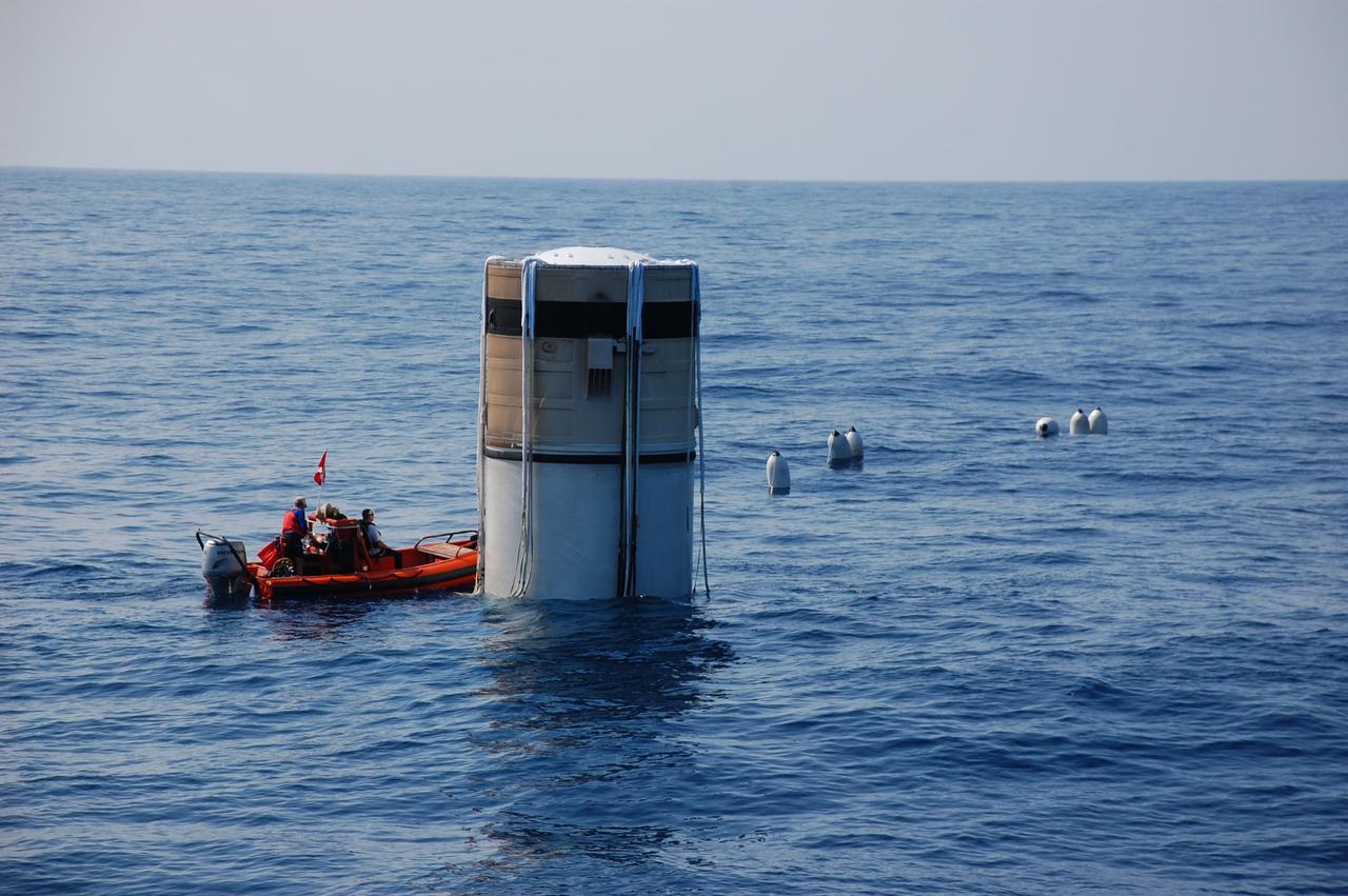 CAPE CANAVERAL, Fla. -- Crew members from Freedom Star, one of NASA's solid rocket booster retrieval ships, have attached a line, held up by flotation devices, between the left spent booster parachute and the ship.               The shuttle’s two solid rocket booster casings and associated flight hardware are recovered in the Atlantic Ocean after every launch by Liberty Star and Freedom Star. The boosters impact the Atlantic about seven minutes after liftoff and the retrieval ships are stationed about 10 miles from the impact area at the time of splashdown. After the spent segments are processed, they will be transported to Utah, where they will be refurbished and stored, if needed. Photo credit: NASA/Ben Smegelsky