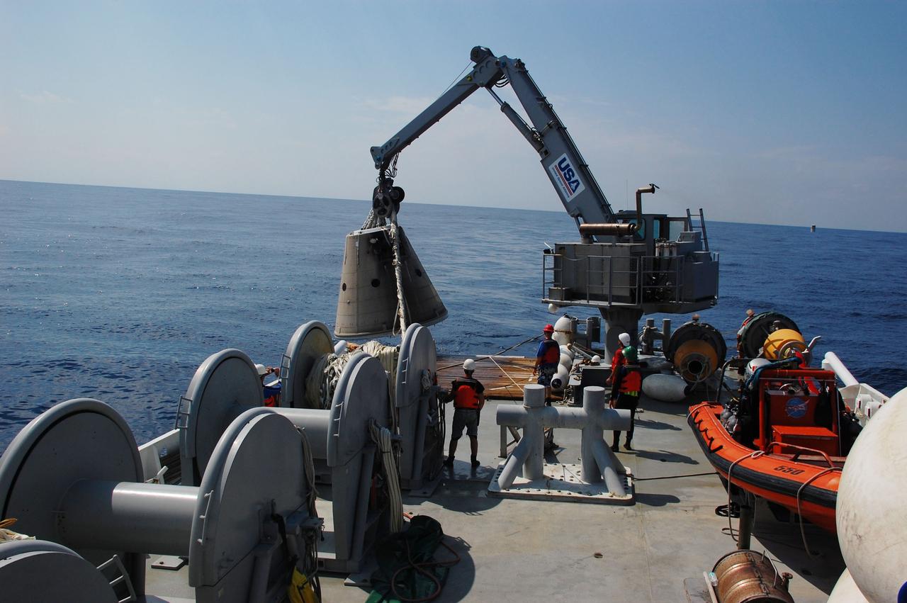 CAPE CANAVERAL, Fla. -- A crane on Freedom Star, one of NASA's solid rocket booster retrieval ships, heaves a spent booster nose cap from the from out of the Atlantic Ocean and onto the deck after space shuttle Discovery's final launch.          The shuttle’s two solid rocket booster casings and associated flight hardware are recovered in the Atlantic Ocean after every launch by Liberty Star and Freedom Star. The boosters impact the Atlantic about seven minutes after liftoff and the retrieval ships are stationed about 10 miles from the impact area at the time of splashdown. After the spent segments are processed, they will be transported to Utah, where they will be refurbished and stored, if needed. Photo credit: NASA/Ben Smegelsky