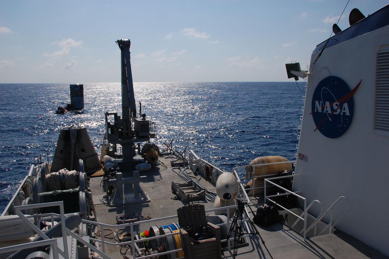 CAPE CANAVERAL, Fla. -- Freedom Star, one of NASA's solid rocket booster retrieval ships, waits for crew members near the left spent booster bobbing in the Atlantic Ocean to attach a hose between it and the vessel that will facilitate debris and water clearing and the pumping in of air so the booster can float horizontally on the water's surface for towing back to Port Canaveral in Florida.                The shuttle’s two solid rocket booster casings and associated flight hardware are recovered in the Atlantic Ocean after every launch by Liberty Star and Freedom Star. The boosters impact the Atlantic about seven minutes after liftoff and the retrieval ships are stationed about 10 miles from the impact area at the time of splashdown. After the spent segments are processed, they will be transported to Utah, where they will be refurbished and stored, if needed. Photo credit: NASA/Ben Smegelsky