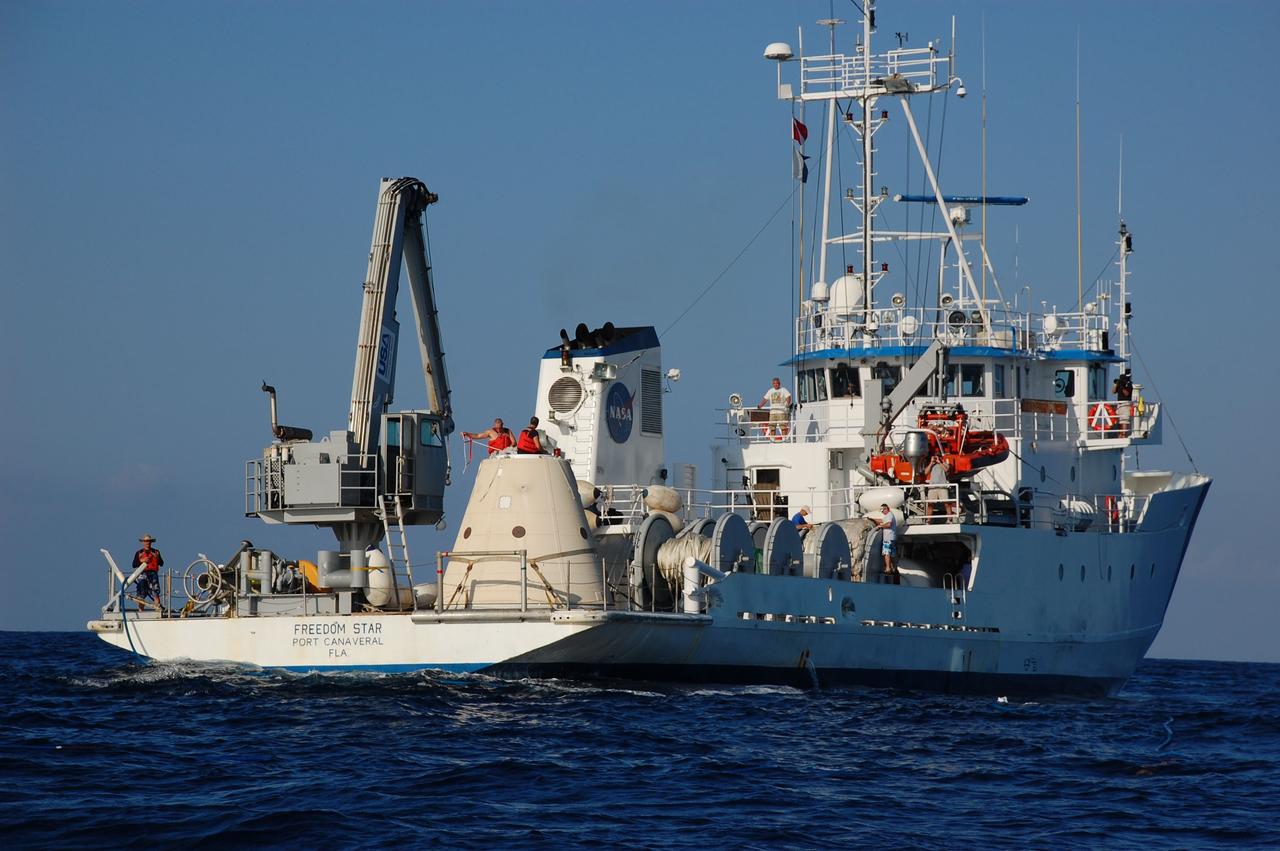 CAPE CANAVERAL, Fla. -- Crew members on Freedom Star, one of NASA's solid rocket booster retrieval ships, monitor the progress of the left spent booster from space shuttle Discovery's final launch, as it is elevated out of the water so it can float horizontally for towing back to Port Canaveral in Florida.        The shuttle’s two solid rocket booster casings and associated flight hardware are recovered in the Atlantic Ocean after every launch by Liberty Star and Freedom Star. The boosters impact the Atlantic about seven minutes after liftoff and the retrieval ships are stationed about 10 miles from the impact area at the time of splashdown. After the spent segments are processed, they will be transported to Utah, where they will be refurbished and stored, if needed. Photo credit: NASA/Ben Smegelsky