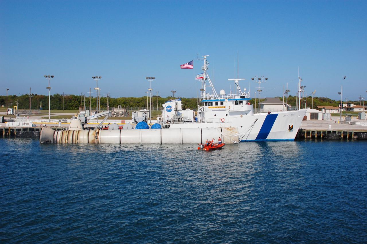 CAPE CANAVERAL, Fla. -- Freedom Star, one of NASA's solid rocket booster retrieval ships, is docked at Port Canaveral, Florida. The left spent booster from space shuttle Discovery's final launch is being positioned along side the vessel before continuing on to Hangar AF at Cape Canaveral Air Force Station.      The shuttle’s two solid rocket booster casings and associated flight hardware are recovered in the Atlantic Ocean after every launch by Liberty Star and Freedom Star. The boosters impact the Atlantic about seven minutes after liftoff and the retrieval ships are stationed about 10 miles from the impact area at the time of splashdown. After the spent segments are processed, they will be transported to Utah, where they will be refurbished and stored, if needed. Photo credit: NASA/Ben Smegelsky