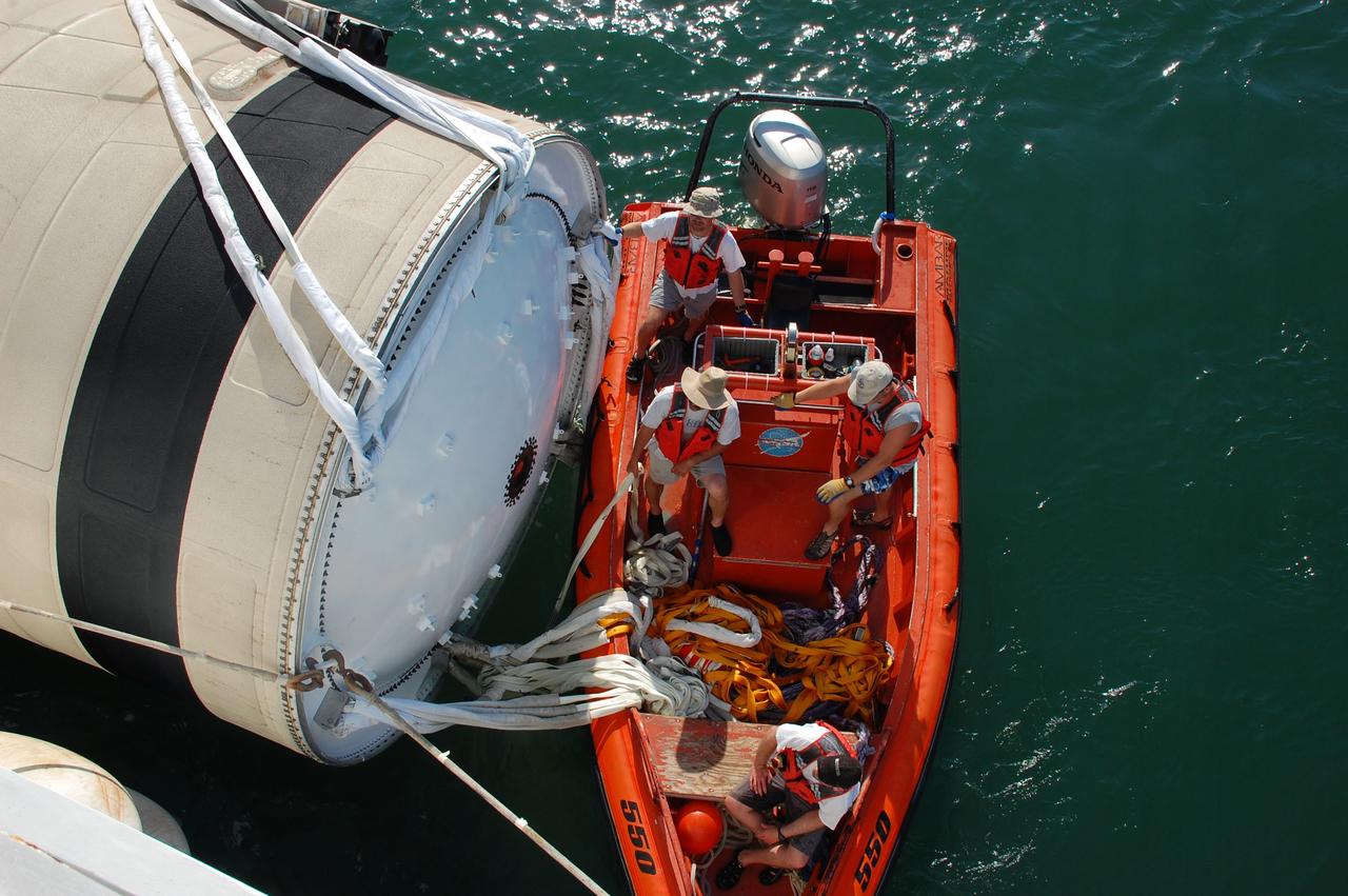 CAPE CANAVERAL, Fla. -- Crew members from Freedom Star, one of NASA's solid rocket booster retrieval ships, check the securing of the left spent booster from space shuttle Discovery's final launch, to the vessel, before continuing on the Hangar AF at Cape Canaveral Air Force Station.          The shuttle’s two solid rocket booster casings and associated flight hardware are recovered in the Atlantic Ocean after every launch by Liberty Star and Freedom Star. The boosters impact the Atlantic about seven minutes after liftoff and the retrieval ships are stationed about 10 miles from the impact area at the time of splashdown. After the spent segments are processed, they will be transported to Utah, where they will be refurbished and stored, if needed. Photo credit: NASA/Ben Smegelsky