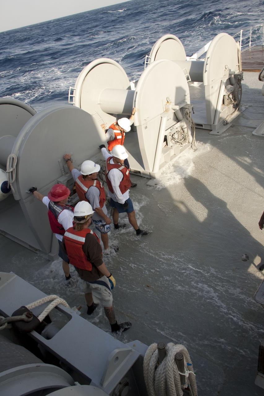 CAPE CANAVERAL, Fla. -- Crew members of Liberty Star, one of NASA's solid rocket booster retrieval ships, hold on tightly to handle grips as the swells of the Atlantic Ocean cause the vessel to pitch and roll while heading toward the recovery area where the right spent booster splashed down after Discovery's final launch.            The shuttle’s two solid rocket booster casings and associated flight hardware are recovered in the Atlantic Ocean after every launch by Freedom Star and Liberty Star. The boosters impact the Atlantic about seven minutes after liftoff and the retrieval ships are stationed about 10 miles from the impact area at the time of splashdown. After the spent segments are processed, they will be transported to Utah, where they will be refurbished and stored, if needed. Photo credit: NASA/Frank Michaux