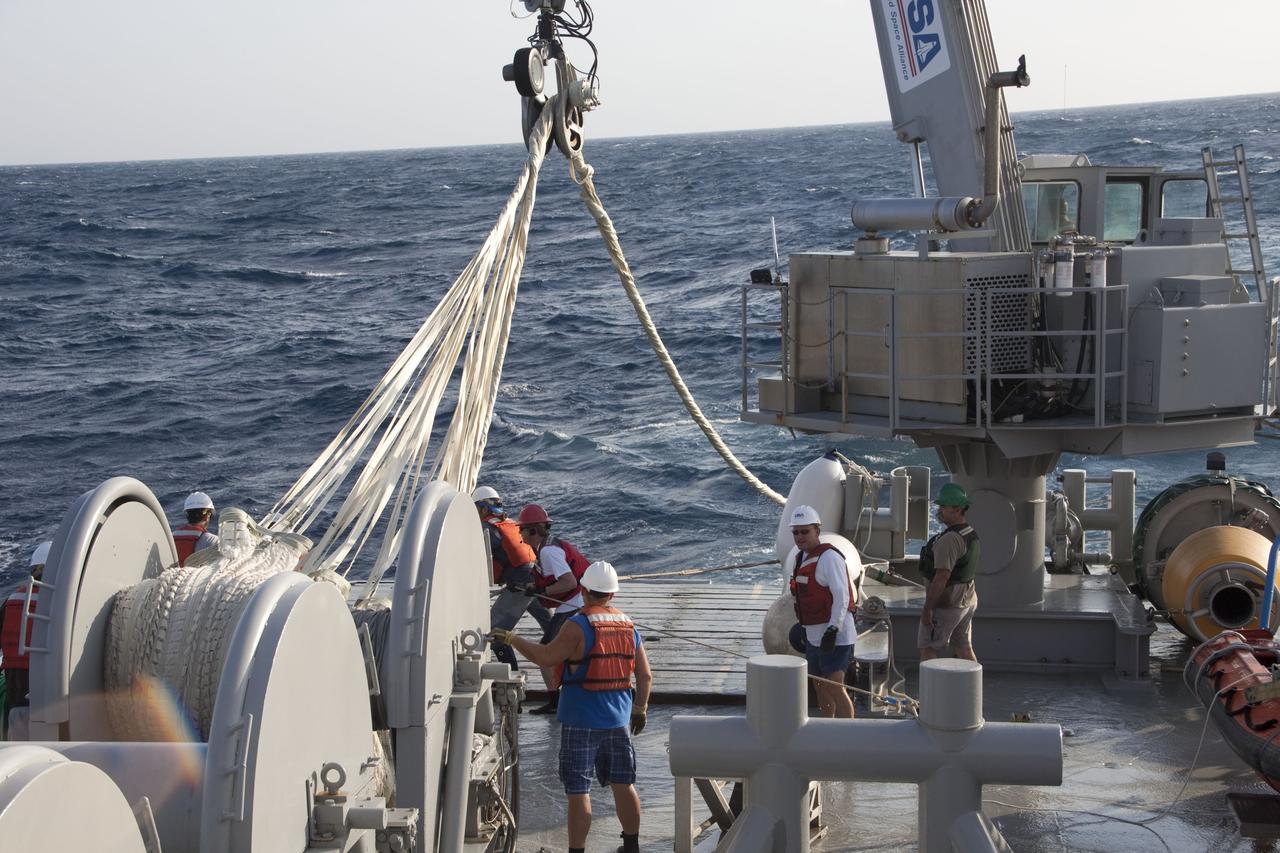 CAPE CANAVERAL, Fla. -- Crew members on Liberty Star, one of NASA's solid rocket booster retrieval ships, use a crane to haul the parachute from the right spent booster onto the ship after it splashed down in the Atlantic Ocean after Discovery's final launch.        The shuttle’s two solid rocket booster casings and associated flight hardware are recovered in the Atlantic Ocean after every launch by Freedom Star and Liberty Star. The boosters impact the Atlantic about seven minutes after liftoff and the retrieval ships are stationed about 10 miles from the impact area at the time of splashdown. After the spent segments are processed, they will be transported to Utah, where they will be refurbished and stored, if needed. Photo credit: NASA/Frank Michaux