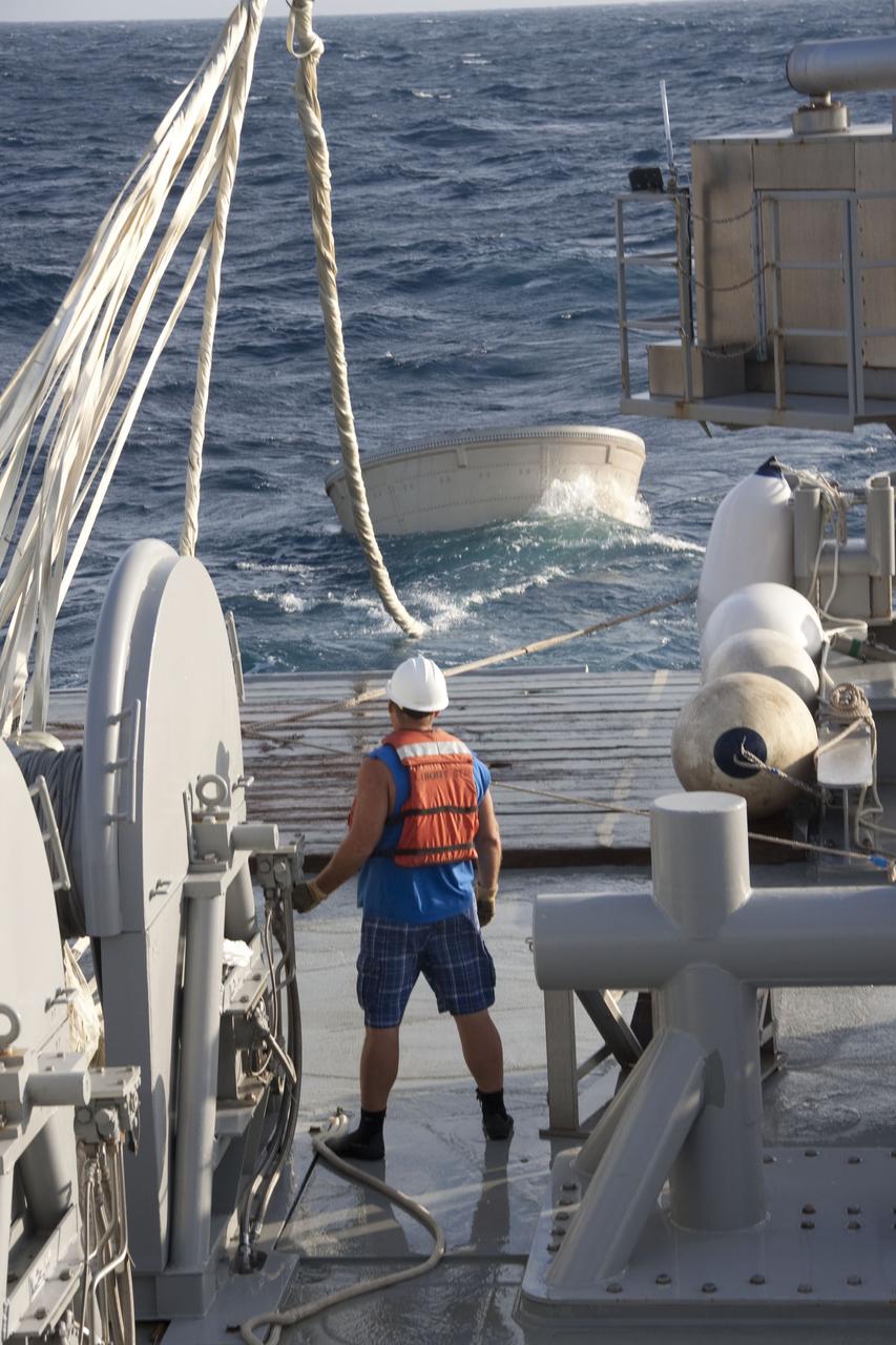 CAPE CANAVERAL, Fla. -- A crew member on Liberty Star, one of NASA's solid rocket booster retrieval ships, uses a crane to haul the right booster nose cap out of the Atlantic Ocean that splashed down after Discovery's final launch.      The shuttle’s two solid rocket booster casings and associated flight hardware are recovered in the Atlantic Ocean after every launch by Freedom Star and Liberty Star. The boosters impact the Atlantic about seven minutes after liftoff and the retrieval ships are stationed about 10 miles from the impact area at the time of splashdown. After the spent segments are processed, they will be transported to Utah, where they will be refurbished and stored, if needed. Photo credit: NASA/Frank Michaux
