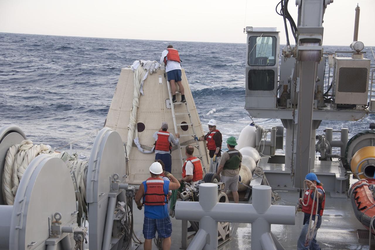 CAPE CANAVERAL, Fla. -- Crew members from Liberty Star, one of NASA's solid rocket booster retrieval ships, work on the parachute from the right spent booster nose cap that splashed down in the Atlantic Ocean after Discovery's final launch.      The shuttle’s two solid rocket booster casings and associated flight hardware are recovered in the Atlantic Ocean after every launch by Freedom Star and Liberty Star. The boosters impact the Atlantic about seven minutes after liftoff and the retrieval ships are stationed about 10 miles from the impact area at the time of splashdown. After the spent segments are processed, they will be transported to Utah, where they will be refurbished and stored, if needed. Photo credit: NASA/Frank Michaux