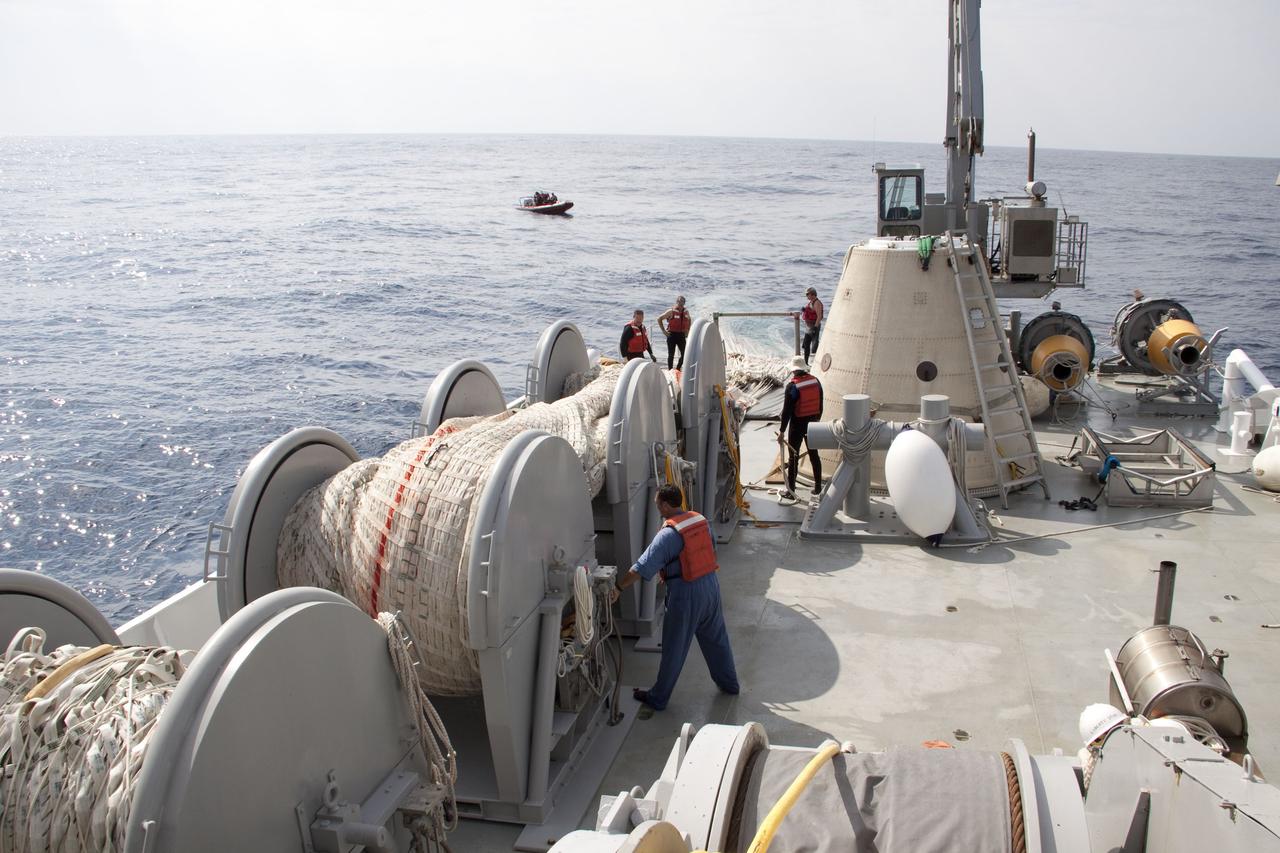 CAPE CANAVERAL, Fla. -- Crew members on board Liberty Star, one of NASA's solid rocket booster retrieval ships, haul in the massive parachute from the right spent booster from space shuttle Discovery's final launch.                          The shuttle's two solid rocket booster casings and associated flight hardware are recovered in the Atlantic Ocean after every launch by Freedom Star and Liberty Star. The boosters impact the Atlantic about seven minutes after liftoff and the retrieval ships are stationed about 10 miles from the impact area at the time of splashdown. After the spent segments are processed, they will be transported to Utah, where they will be refurbished and stored, if needed. Photo credit: NASA/Frank Michaux