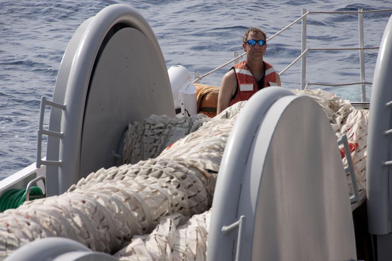 CAPE CANAVERAL, Fla. -- A crew member on Liberty Star, one of NASA's solid rocket booster retrieval ships, monitors the progress as the massive parachute from the right spent booster from space shuttle Discovery's final launch is hauled on board.                           The shuttle's two solid rocket booster casings and associated flight hardware are recovered in the Atlantic Ocean after every launch by Freedom Star and Liberty Star. The boosters impact the Atlantic about seven minutes after liftoff and the retrieval ships are stationed about 10 miles from the impact area at the time of splashdown. After the spent segments are processed, they will be transported to Utah, where they will be refurbished and stored, if needed. Photo credit: NASA/Frank Michaux