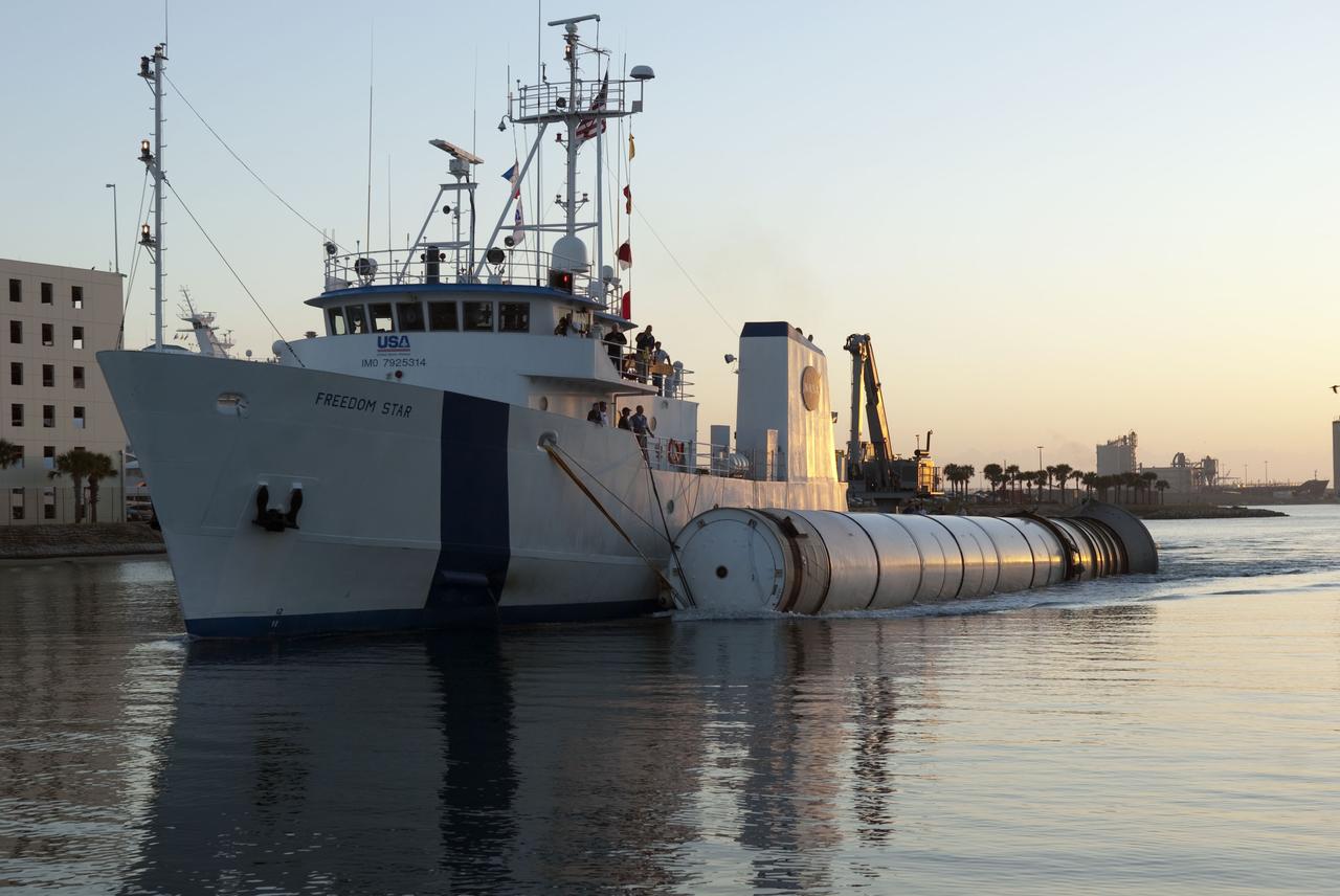 CAPE CANAVERAL, Fla. -- The Solid Rocket Booster Retrieval Ship Freedom Star, with a booster in tow, passes through Port Canaveral on its journey to Hangar AF at Cape Canaveral Air Force Station in Florida. The booster was used during space shuttle Discovery's STS-133 launch from NASA Kennedy Space Center's Launch Pad 39A on Feb. 24. The shuttle’s two solid rocket booster casings and associated flight hardware are recovered in the Atlantic Ocean after every launch by Liberty Star and Freedom Star. The boosters impact the Atlantic about seven minutes after liftoff and the retrieval ships are stationed about 10 miles from the impact area at the time of splashdown. After the spent segments are processed, they will be transported to Utah, where they will be refurbished and stored, if needed. Photo credit: NASA/Jim Grossmann