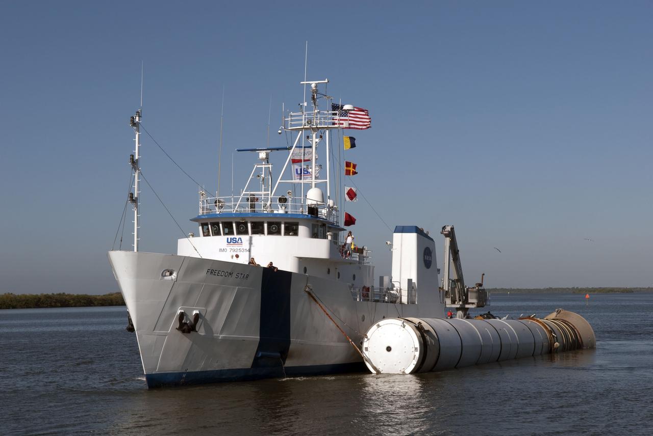CAPE CANAVERAL, Fla. -- The Solid Rocket Booster Retrieval Ship Freedom Star tows a booster to the dock at Hangar AF on Cape Canaveral Air Force Station in Florida. The booster was used during space shuttle Discovery's STS-133 launch from NASA Kennedy Space Center's Launch Pad 39A on Feb. 24. The shuttle’s two solid rocket booster casings and associated flight hardware are recovered in the Atlantic Ocean after every launch by Liberty Star and Freedom Star. The boosters impact the Atlantic about seven minutes after liftoff and the retrieval ships are stationed about 10 miles from the impact area at the time of splashdown. After the spent segments are processed, they will be transported to Utah, where they will be refurbished and stored, if needed. Photo credit: NASA/Jim Grossmann