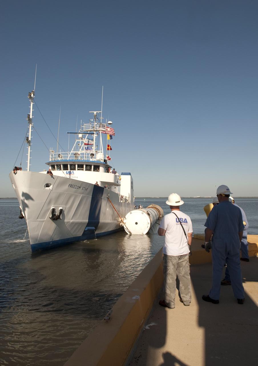 CAPE CANAVERAL, Fla. -- The Solid Rocket Booster Retrieval Ship Freedom Star tows a booster to the dock at Hangar AF on Cape Canaveral Air Force Station in Florida. The booster was used during space shuttle Discovery's STS-133 launch from NASA Kennedy Space Center's Launch Pad 39A on Feb. 24. The shuttle’s two solid rocket booster casings and associated flight hardware are recovered in the Atlantic Ocean after every launch by Liberty Star and Freedom Star. The boosters impact the Atlantic about seven minutes after liftoff and the retrieval ships are stationed about 10 miles from the impact area at the time of splashdown. After the spent segments are processed, they will be transported to Utah, where they will be refurbished and stored, if needed. Photo credit: NASA/Jim Grossmann
