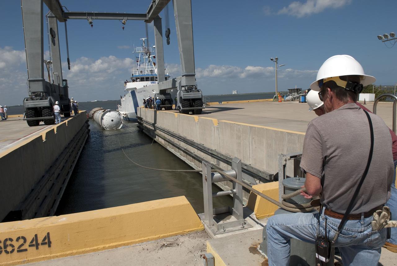 CAPE CANAVERAL, Fla. -- The left spent booster used during space shuttle Discovery's final launch is moved into a hoisting slip at the Solid Rocket Booster Disassembly Facility at Hangar AF on Cape Canaveral Air Force Station in Florida.          The shuttle's two solid rocket booster casings and associated flight hardware are recovered in the Atlantic Ocean after every launch by Freedom Star and Liberty Star. The boosters impact the Atlantic about seven minutes after liftoff and the retrieval ships are stationed about 10 miles from the impact area at the time of splashdown. After the spent segments are processed, they will be transported to Utah, where they will be refurbished and stored, if needed. Photo credit: NASA/Jim Grossmann