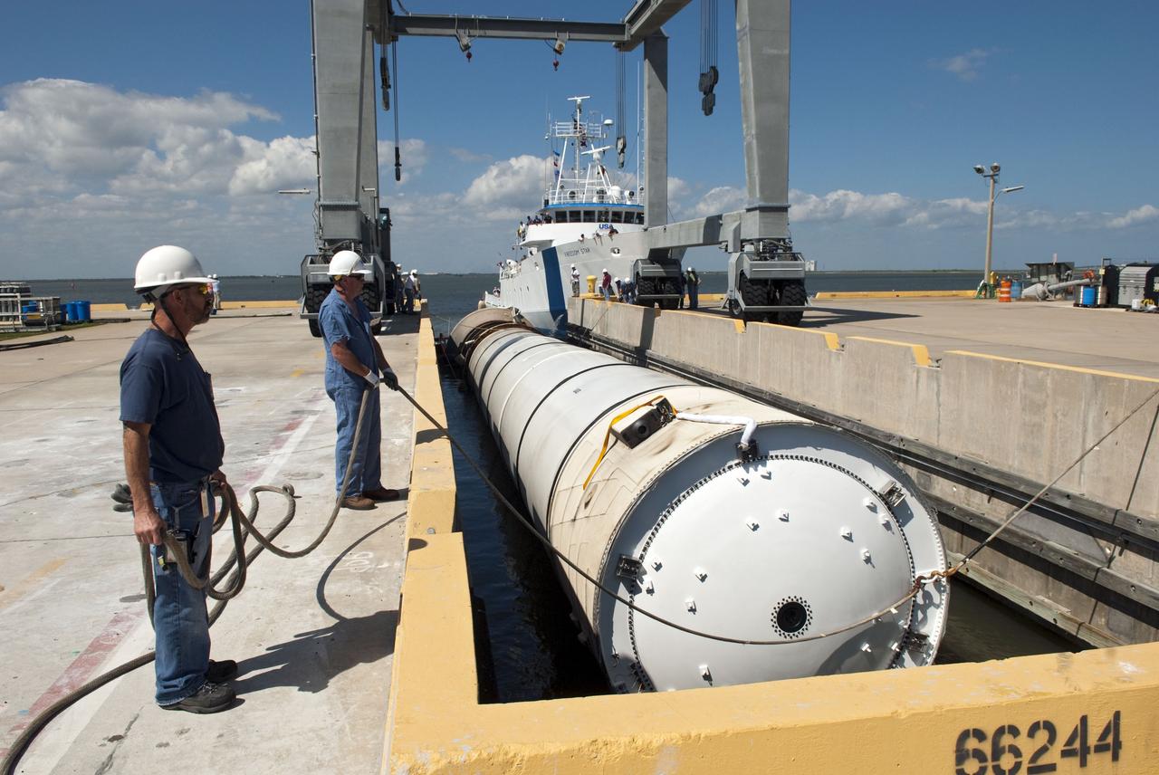 CAPE CANAVERAL, Fla. -- The left spent booster used during space shuttle Discovery's final launch is guided into a hoisting slip at the Solid Rocket Booster Disassembly Facility at Hangar AF on Cape Canaveral Air Force Station in Florida. The shuttle's two solid rocket booster casings and associated flight hardware are recovered in the Atlantic Ocean after every launch by Freedom Star and Liberty Star. The boosters impact the Atlantic about seven minutes after liftoff and the retrieval ships are stationed about 10 miles from the impact area at the time of splashdown. After the spent segments are processed, they will be transported to Utah, where they will be refurbished and stored, if needed. Photo credit: NASA/Jim Grossmann