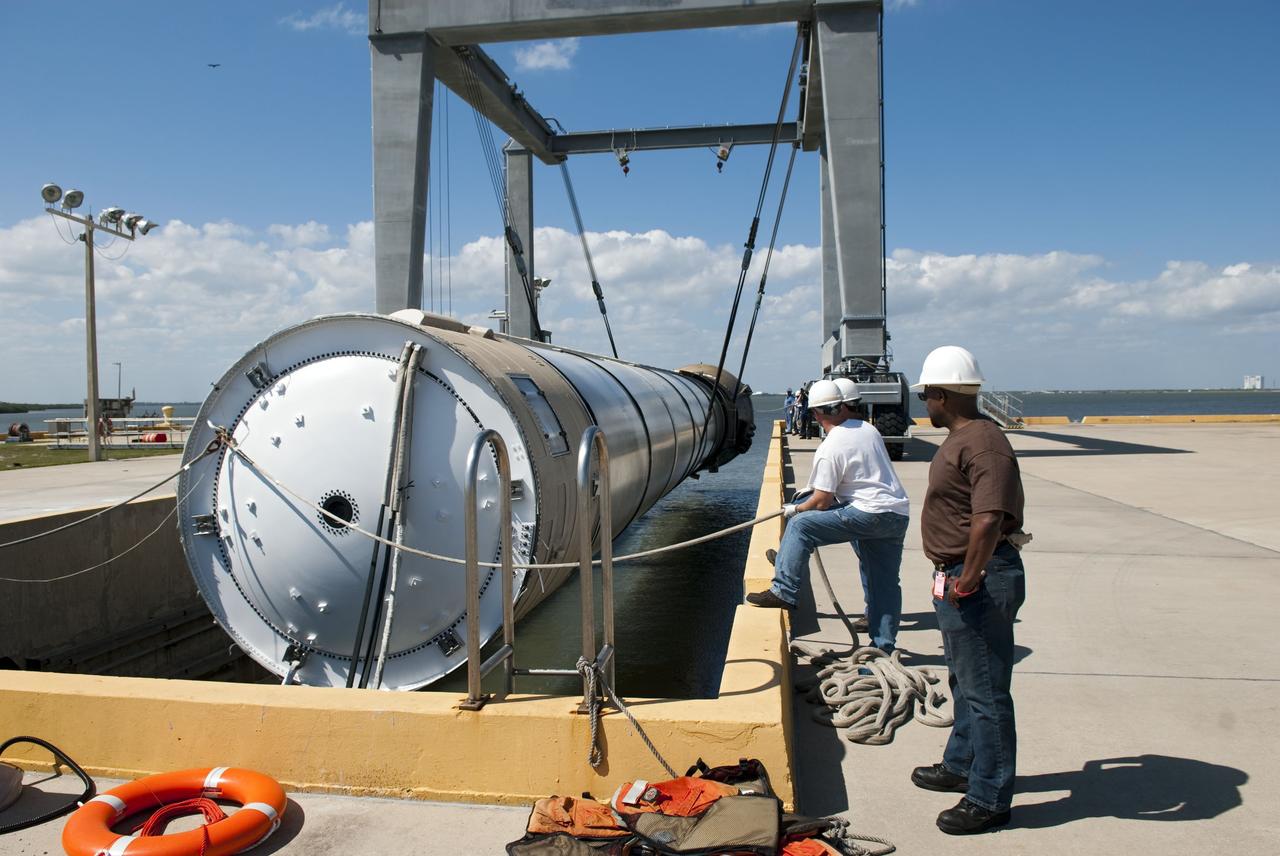 CAPE CANAVERAL, Fla. -- Workers at the hoisting slip at the Solid Rocket Booster Disassembly Facility at Hangar AF on Cape Canaveral Air Force Station in Florida, monitor the lifting of the left spent booster, used during space shuttle Discovery's final launch. The shuttle's two solid rocket booster casings and associated flight hardware are recovered in the Atlantic Ocean after every launch by Freedom Star and Liberty Star. The boosters impact the Atlantic about seven minutes after liftoff and the retrieval ships are stationed about 10 miles from the impact area at the time of splashdown. After the spent segments are processed, they will be transported to Utah, where they will be refurbished and stored, if needed. Photo credit: NASA/Jim Grossmann