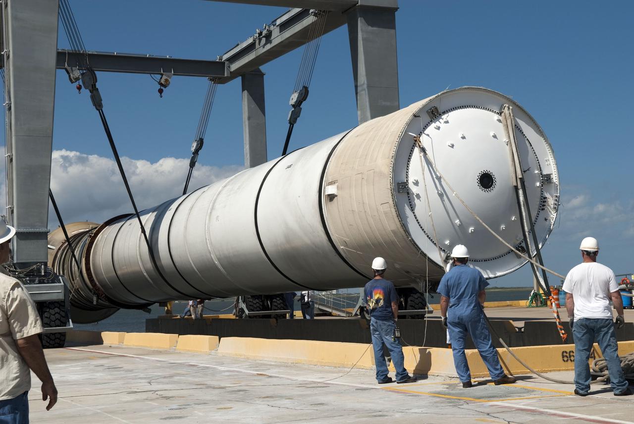 CAPE CANAVERAL, Fla. -- Workers at the hoisting slip at the Solid Rocket Booster Disassembly Facility at Hangar AF on Cape Canaveral Air Force Station in Florida, monitor the lifting of the left spent booster, used during space shuttle Discovery's final launch. The shuttle's two solid rocket booster casings and associated flight hardware are recovered in the Atlantic Ocean after every launch by Freedom Star and Liberty Star. The boosters impact the Atlantic about seven minutes after liftoff and the retrieval ships are stationed about 10 miles from the impact area at the time of splashdown. After the spent segments are processed, they will be transported to Utah, where they will be refurbished and stored, if needed. Photo credit: NASA/Jim Grossmann
