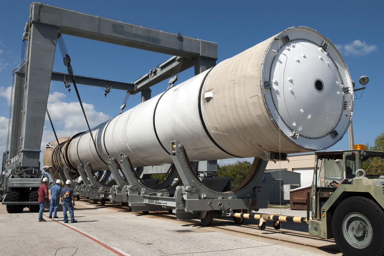 CAPE CANAVERAL, Fla. -- At the Solid Rocket Booster Disassembly Facility at Hangar AF on Cape Canaveral Air Force Station in Florida, the left spent booster, used during space shuttle Discovery's final launch, is lowered onto a tracked dolly for processing.      The shuttle's two solid rocket booster casings and associated flight hardware are recovered in the Atlantic Ocean after every launch by Freedom Star and Liberty Star. The boosters impact the Atlantic about seven minutes after liftoff and the retrieval ships are stationed about 10 miles from the impact area at the time of splashdown. After the spent segments are processed, they will be transported to Utah, where they will be refurbished and stored, if needed. Photo credit: NASA/Jim Grossmann