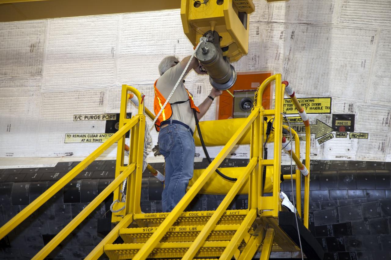 CAPE CANAVERAL, Fla. -- In the transfer aisle of the Vehicle Assembly Building at NASA's Kennedy Space Center in Florida, a worker attaches an overhead crane to space shuttle Endeavour. The crane will lift the spacecraft into a high bay where it will be attached to its external fuel tank and solid rocket boosters for its final mission, STS-134. Endeavour and its STS-134 crew will deliver the Express Logistics Carrier-3, Alpha Magnetic Spectrometer, a high-pressure gas tank, additional spare parts for Dextre and micrometeoroid debris shields to the International Space Station. Launch is targeted for April 19 at 7:48 p.m. EDT. For more information visit, http://www.nasa.gov/mission_pages/shuttle/shuttlemissions/sts134/index.html. Photo credit: NASA/Frankie Martin