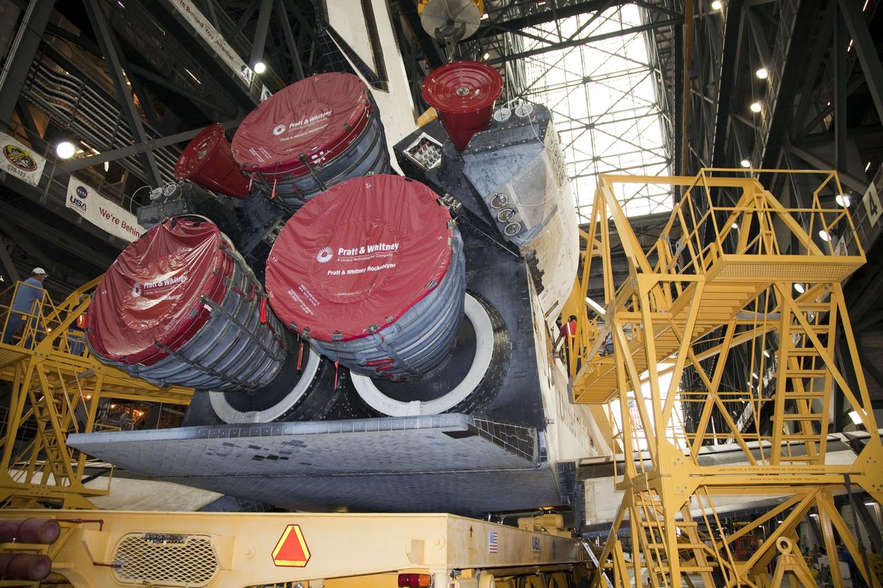 CAPE CANAVERAL, Fla. -- In the transfer aisle of the Vehicle Assembly Building at NASA's Kennedy Space Center in Florida, this image shows the rear of space shuttle Endeavour and it covered three main engines as a worker attaches an overhead crane. The crane will lift the spacecraft into a high bay where it will be attached to its external fuel tank and solid rocket boosters for its final mission, STS-134. Endeavour and its STS-134 crew will deliver the Express Logistics Carrier-3, Alpha Magnetic Spectrometer, a high-pressure gas tank, additional spare parts for Dextre and micrometeoroid debris shields to the International Space Station. Launch is targeted for April 19 at 7:48 p.m. EDT. For more information visit, http://www.nasa.gov/mission_pages/shuttle/shuttlemissions/sts134/index.html. Photo credit: NASA/Frankie Martin