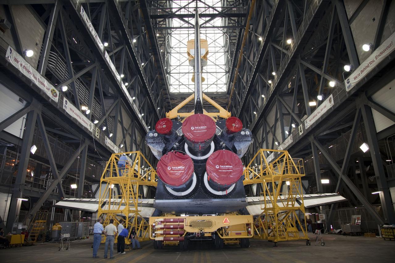 CAPE CANAVERAL, Fla. -- In the transfer aisle of the Vehicle Assembly Building at NASA's Kennedy Space Center in Florida, this image shows the rear of space shuttle Endeavour and it covered three main engines as a worker attaches an overhead crane. The crane will lift the spacecraft into a high bay where it will be attached to its external fuel tank and solid rocket boosters for its final mission, STS-134. Endeavour and its STS-134 crew will deliver the Express Logistics Carrier-3, Alpha Magnetic Spectrometer, a high-pressure gas tank, additional spare parts for Dextre and micrometeoroid debris shields to the International Space Station. Launch is targeted for April 19 at 7:48 p.m. EDT. For more information visit, http://www.nasa.gov/mission_pages/shuttle/shuttlemissions/sts134/index.html. Photo credit: NASA/Frankie Martin