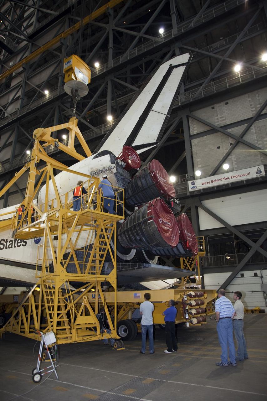 CAPE CANAVERAL, Fla. -- In the transfer aisle of the Vehicle Assembly Building at NASA's Kennedy Space Center in Florida, workers attach an overhead crane to the rear of space shuttle Endeavour. The crane will lift the spacecraft into a high bay where it will be attached to its external fuel tank and solid rocket boosters for its final mission, STS-134. Endeavour and its STS-134 crew will deliver the Express Logistics Carrier-3, Alpha Magnetic Spectrometer, a high-pressure gas tank, additional spare parts for Dextre and micrometeoroid debris shields to the International Space Station. Launch is targeted for April 19 at 7:48 p.m. EDT. For more information visit, http://www.nasa.gov/mission_pages/shuttle/shuttlemissions/sts134/index.html. Photo credit: NASA/Frankie Martin
