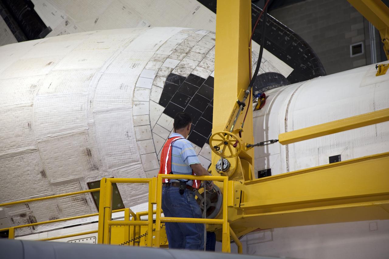 CAPE CANAVERAL, Fla. -- In the transfer aisle of the Vehicle Assembly Building at NASA's Kennedy Space Center in Florida, a worker attaches an overhead crane to space shuttle Endeavour. The crane will lift the spacecraft into a high bay where it will be attached to its external fuel tank and solid rocket boosters for its final mission, STS-134. Endeavour and its STS-134 crew will deliver the Express Logistics Carrier-3, Alpha Magnetic Spectrometer, a high-pressure gas tank, additional spare parts for Dextre and micrometeoroid debris shields to the International Space Station. Launch is targeted for April 19 at 7:48 p.m. EDT. For more information visit, http://www.nasa.gov/mission_pages/shuttle/shuttlemissions/sts134/index.html. Photo credit: NASA/Frankie Martin