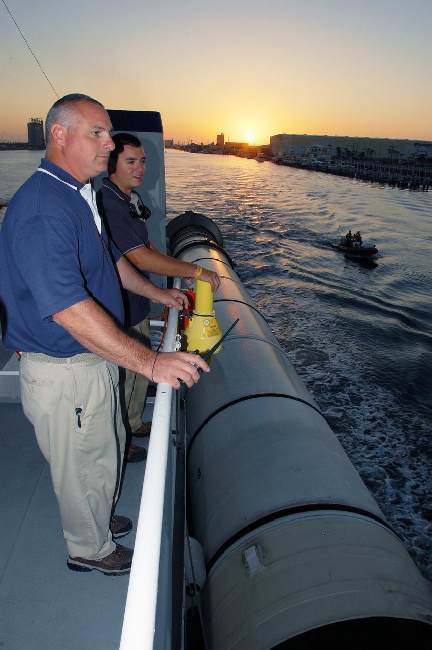 CAPE CANAVERAL, Fla. -- As daylight breaks, Allan Gravina and Cody Gordon with United Space Alliance monitor a spent booster as it's towed by the Freedom Star retrieval ship through Port Canaveral in Florida on a journey to Hangar AF at Cape Canaveral Air Force Station. The booster was used during space shuttle Discovery's STS-133 launch from NASA Kennedy Space Center's Launch Pad 39A on Feb. 24. The shuttle’s two solid rocket booster casings and associated flight hardware are recovered in the Atlantic Ocean after every launch by Freedom Star and Liberty Star.          The boosters impact the Atlantic about seven minutes after liftoff and the retrieval ships are stationed about 10 miles from the impact area at the time of splashdown.  After the spent segments are processed, they will be transported to Utah, where they will be refurbished and stored, if needed. Photo credit: NASA/Ben Smegelsky