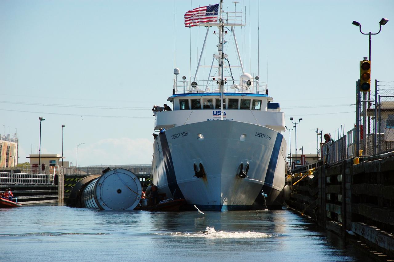 CAPE CANAVERAL, Fla. -- Liberty Star, one of NASA's solid rocket booster retrieval ships, ushers a spent shuttle booster to Hangar AF at Cape Canaveral Air Force Station in Florida. The booster was used during space shuttle Discovery's STS-133 launch from NASA Kennedy Space Center's Launch Pad 39A on Feb. 24. The shuttle’s two solid rocket booster casings and associated flight hardware are recovered in the Atlantic Ocean after every launch by Freedom Star and Liberty Star. The boosters impact the Atlantic about seven minutes after liftoff and the retrieval ships are stationed about 10 miles from the impact area at the time of splashdown.  After the spent segments are processed, they will be transported to Utah, where they will be refurbished and stored, if needed. Photo credit: NASA/Ben Smegelsky