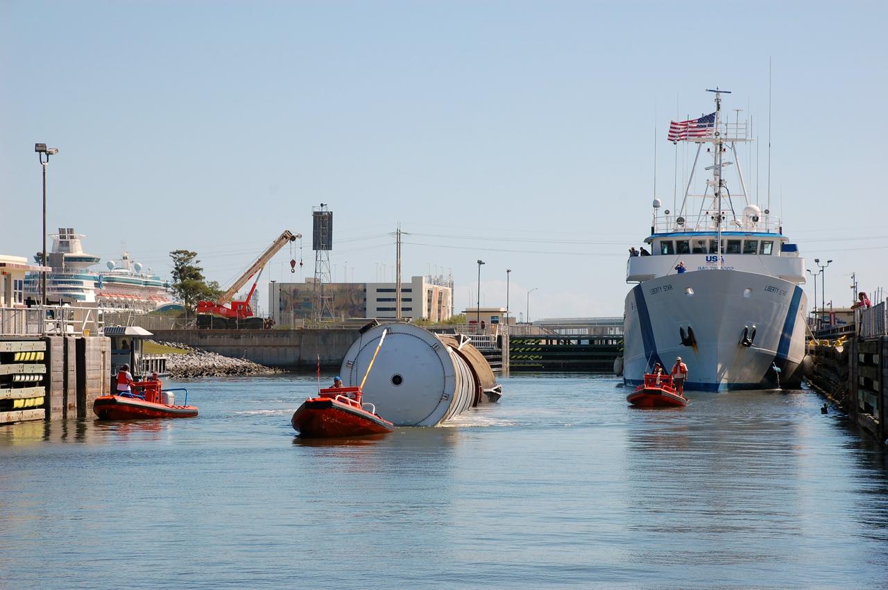 CAPE CANAVERAL, Fla. -- Crew members in a skiff and aboard Liberty Star, one of NASA's solid rocket booster retrieval ships, usher a spent shuttle booster to Hangar AF at Cape Canaveral Air Force Station in Florida. The booster was used during space shuttle Discovery's STS-133 launch from NASA Kennedy Space Center's Launch Pad 39A on Feb. 24. The shuttle’s two solid rocket booster casings and associated flight hardware are recovered in the Atlantic Ocean after every launch by Freedom Star and Liberty Star. The boosters impact the Atlantic about seven minutes after liftoff and the retrieval ships are stationed about 10 miles from the impact area at the time of splashdown. After the spent segments are processed, they will be transported to Utah, where they will be refurbished and stored, if needed. Photo credit: NASA/Ben Smegelsky