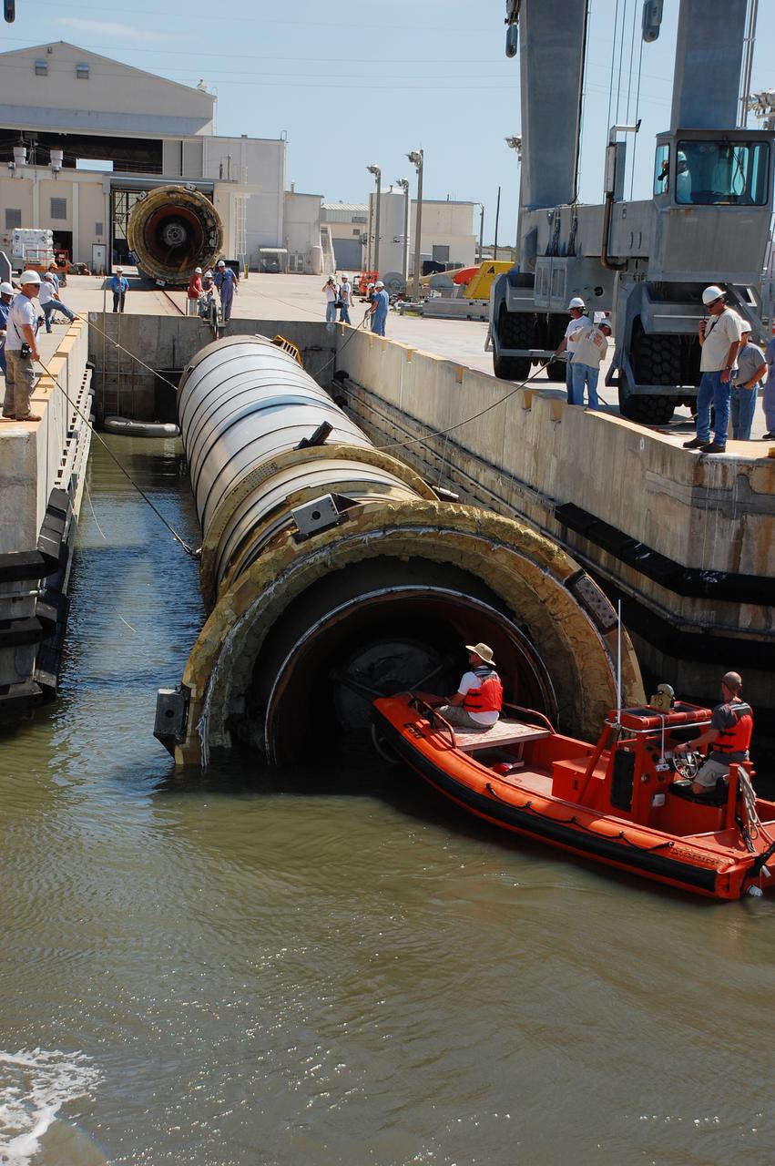 CAPE CANAVERAL, Fla. -- Crew members in a skiff from Liberty Star, one of NASA's solid rocket booster retrieval ships, usher a spent shuttle booster to Hangar AF at Cape Canaveral Air Force Station in Florida. The booster was used during space shuttle Discovery's STS-133 launch from NASA Kennedy Space Center's Launch Pad 39A on Feb. 24. The shuttle’s two solid rocket booster casings and associated flight hardware are recovered in the Atlantic Ocean after every launch by Freedom Star and Liberty Star. The boosters impact the Atlantic about seven minutes after liftoff and the retrieval ships are stationed about 10 miles from the impact area at the time of splashdown.  After the spent segments are processed, they will be transported to Utah, where they will be refurbished and stored, if needed. Photo credit: NASA/Ben Smegelsky