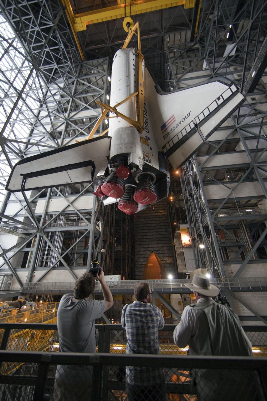 CAPE CANAVERAL, Fla. -- Members of the media snap photos as a large yellow, metal sling lifts shuttle Endeavour from the transfer aisle into a high bay of the Vehicle Assembly Building at NASA's Kennedy Space Center in Florida. In the bay, the shuttle will be attached to its external fuel tank and solid rocket boosters. Endeavour is targeted to roll out to Kennedy's Launch Pad 39A for its final mission, STS-134, on March 9. Endeavour and the six-member crew will deliver the Express Logistics Carrier-3, Alpha Magnetic Spectrometer-2 (AMS), a high-pressure gas tank, additional spare parts for the Dextre robotic helper and micrometeoroid debris shields to the International Space Station. Endeavour's final launch is targeted for April 19 at 7:48 p.m. EDT. For more information visit, http://www.nasa.gov/mission_pages/shuttle/shuttlemissions/sts134/index.html. Photo credit: NASA/Frankie Martin