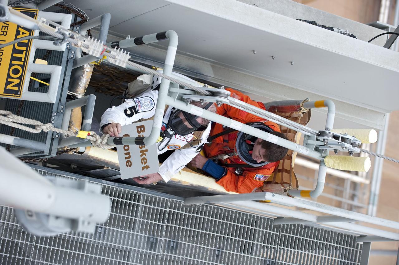 CAPE CANAVERAL, Fla. – An emergency exit, or Mode II/IV, exercise is under way at the slidewire basket area of Launch Pad 39A at NASA's Kennedy Space Center in Florida. The exercise involves NASA fire rescue personnel, volunteers portraying astronauts with simulated injuries, helicopters and personnel from the Air Force’s 920th Rescue Wing, and medical trauma teams at three Central Florida hospitals. The drill allows teams to practice an emergency response at the launch pad, including helicopter evacuation to local hospitals.       Photo credit: NASA/Kim Shiflett