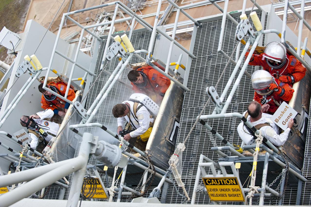 CAPE CANAVERAL, Fla. – An emergency exit, or Mode II/IV, exercise is under way at the slidewire basket area of Launch Pad 39A at NASA's Kennedy Space Center in Florida. The exercise involves NASA fire rescue personnel, volunteers portraying astronauts with simulated injuries, helicopters and personnel from the Air Force’s 920th Rescue Wing, and medical trauma teams at three Central Florida hospitals. The drill allows teams to practice an emergency response at the launch pad, including helicopter evacuation to local hospitals.     Photo credit: NASA/Kim Shiflett