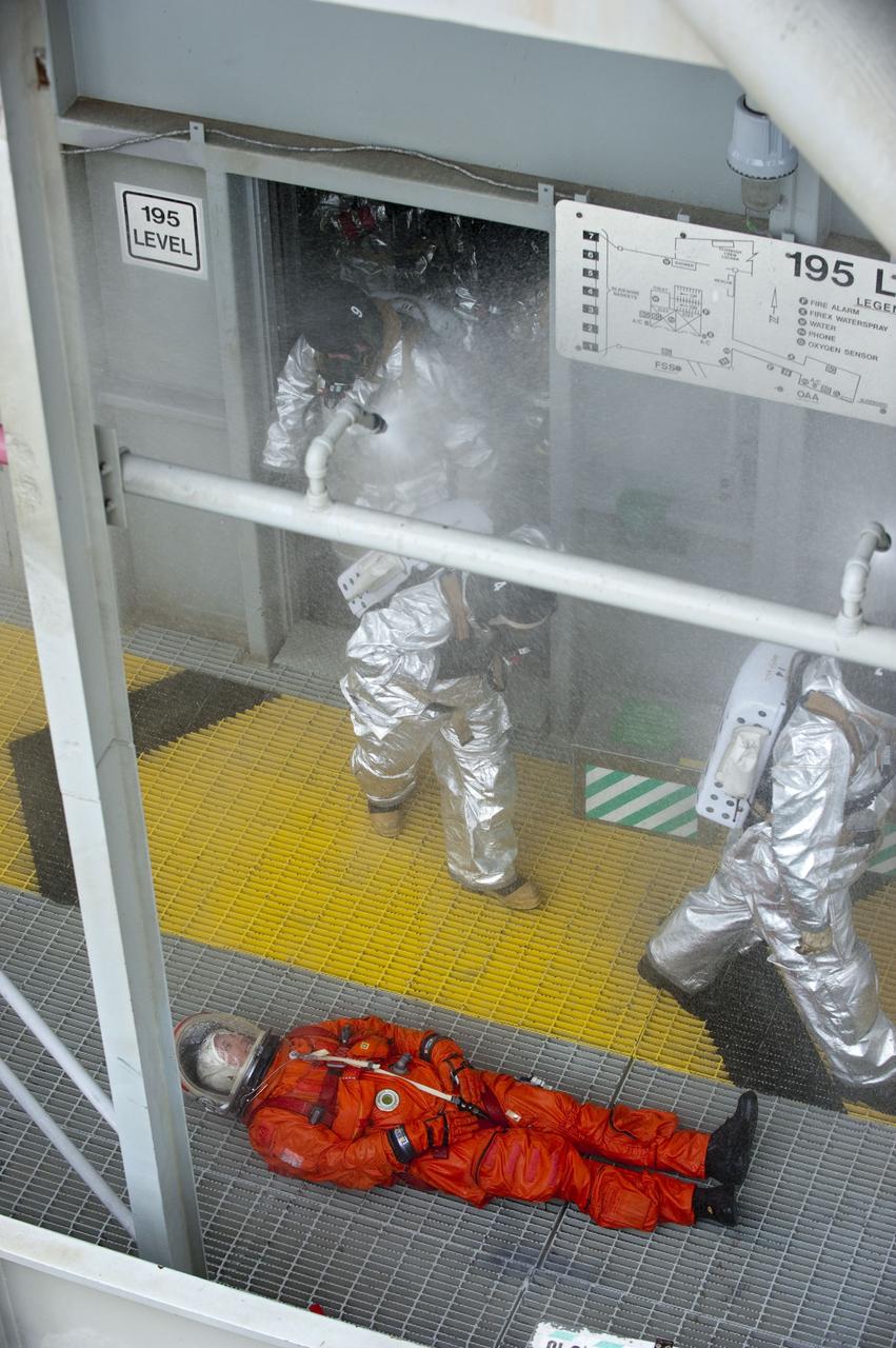 CAPE CANAVERAL, Fla. – An emergency exit, or Mode II/IV, exercise is under way at the 195-foot level of Launch Pad 39A at NASA's Kennedy Space Center in Florida. The exercise involves NASA fire rescue personnel, volunteers portraying astronauts with simulated injuries, helicopters and personnel from the Air Force’s 920th Rescue Wing, and medical trauma teams at three Central Florida hospitals. The drill allows teams to practice an emergency response at the launch pad, including helicopter evacuation to local hospitals.             Photo credit: NASA/Kim Shiflett