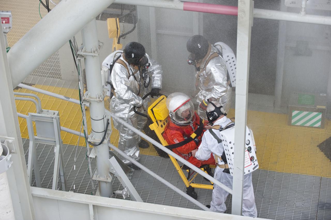 CAPE CANAVERAL, Fla. – An emergency exit, or Mode II/IV, exercise is under way at the 195-foot level of Launch Pad 39A at NASA's Kennedy Space Center in Florida. The exercise involves NASA fire rescue personnel, volunteers portraying astronauts with simulated injuries, helicopters and personnel from the Air Force’s 920th Rescue Wing, and medical trauma teams at three Central Florida hospitals. The drill allows teams to practice an emergency response at the launch pad, including helicopter evacuation to local hospitals.           Photo credit: NASA/Kim Shiflett