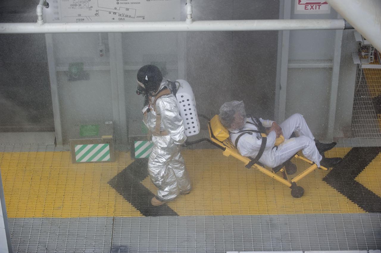CAPE CANAVERAL, Fla. – An emergency exit, or Mode II/IV, exercise is under way at the 195-foot level of Launch Pad 39A at NASA's Kennedy Space Center in Florida. The exercise involves NASA fire rescue personnel, volunteers portraying astronauts with simulated injuries, helicopters and personnel from the Air Force’s 920th Rescue Wing, and medical trauma teams at three Central Florida hospitals. The drill allows teams to practice an emergency response at the launch pad, including helicopter evacuation to local hospitals.         Photo credit: NASA/Kim Shiflett