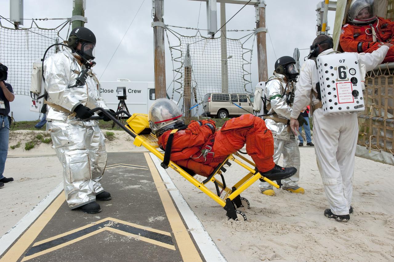CAPE CANAVERAL, Fla. – An emergency exit, or Mode II/IV, exercise is under way at the slidewire basket landing site of Launch Pad 39A at NASA's Kennedy Space Center in Florida. The exercise involves NASA fire rescue personnel, volunteers portraying astronauts with simulated injuries, helicopters and personnel from the Air Force’s 920th Rescue Wing, and medical trauma teams at three Central Florida hospitals. The drill allows teams to practice an emergency response at the launch pad, including helicopter evacuation to local hospitals.     Photo credit: NASA/Kim Shiflett