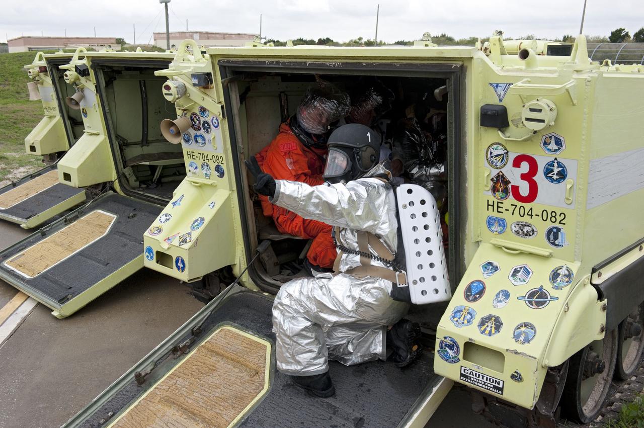 CAPE CANAVERAL, Fla. – On Launch Pad 39A at NASA's Kennedy Space Center in Florida, an emergency exit, or Mode II/IV, exercise is under way. Seen here are M-113 armored personnel carriers near the slidewire basked landing site. The exercise involves NASA fire rescue personnel, volunteers portraying astronauts with simulated injuries, helicopters and personnel from the Air Force’s 920th Rescue Wing, and medical trauma teams at three Central Florida hospitals. The drill allows teams to practice an emergency response at the launch pad, including helicopter evacuation to local hospitals.             Photo credit: NASA/Kim Shiflett