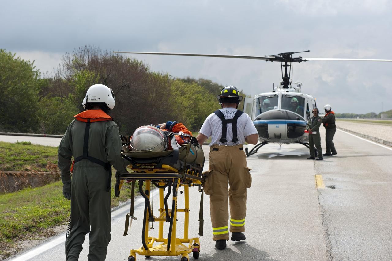 CAPE CANAVERAL, Fla. – Volunteers portraying injured astronauts are transported to a helicopter as part of an emergency exit, or Mode II/IV, exercise that allows teams to practice an emergency response at Launch Pad 39A at NASA's Kennedy Space Center in Florida. The exercise involves NASA fire rescue personnel, volunteers portraying astronauts with simulated injuries, helicopters and personnel from the Air Force’s 920th Rescue Wing, and medical trauma teams at three Central Florida hospitals. The drill allows teams to practice an emergency response at the launch pad, including helicopter evacuation to local hospitals.         Photo credit: NASA/Kim Shiflett