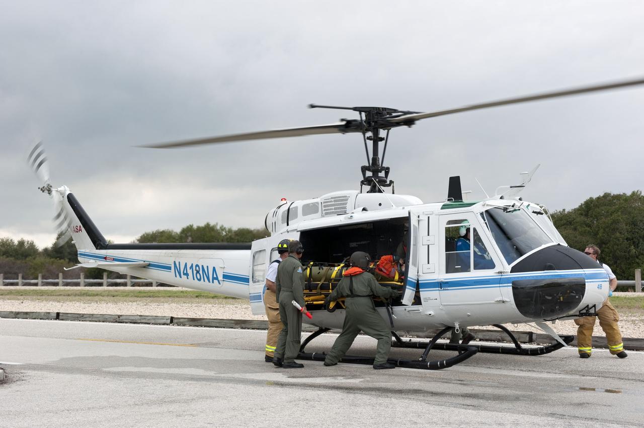 CAPE CANAVERAL, Fla. – Volunteers portraying injured astronauts are loaded onto a helicopter as part of an emergency exit, or Mode II/IV, exercise that allows teams to practice an emergency response at Launch Pad 39A at NASA's Kennedy Space Center in Florida. The exercise involves NASA fire rescue personnel, volunteers portraying astronauts with simulated injuries, helicopters and personnel from the Air Force’s 920th Rescue Wing, and medical trauma teams at three Central Florida hospitals. The drill allows teams to practice an emergency response at the launch pad, including helicopter evacuation to local hospitals.       Photo credit: NASA/Kim Shiflett