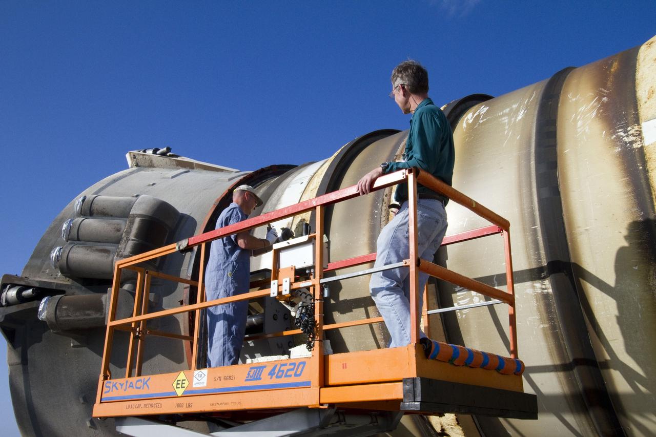 CAPE CANAVERAL, Fla. -- Technicians inspect a spent shuttle solid rocket booster outside Hangar AF at Cape Canaveral Air Force Station in Florida. The booster was used during space shuttle Discovery's STS-133 launch from NASA Kennedy Space Center's Launch Pad 39A on Feb. 24. The shuttle’s two solid rocket booster casings and associated flight hardware were recovered in the Atlantic Ocean by retrieval ships Liberty Star and Freedom Star.          The boosters impact the Atlantic about seven minutes after liftoff and the retrieval ships are stationed about 10 miles from the impact area at the time of splashdown.  After the spent segments are processed, they will be transported to Utah, where they will be refurbished and stored, if needed. Photo credit: NASA/Jack Pfaller