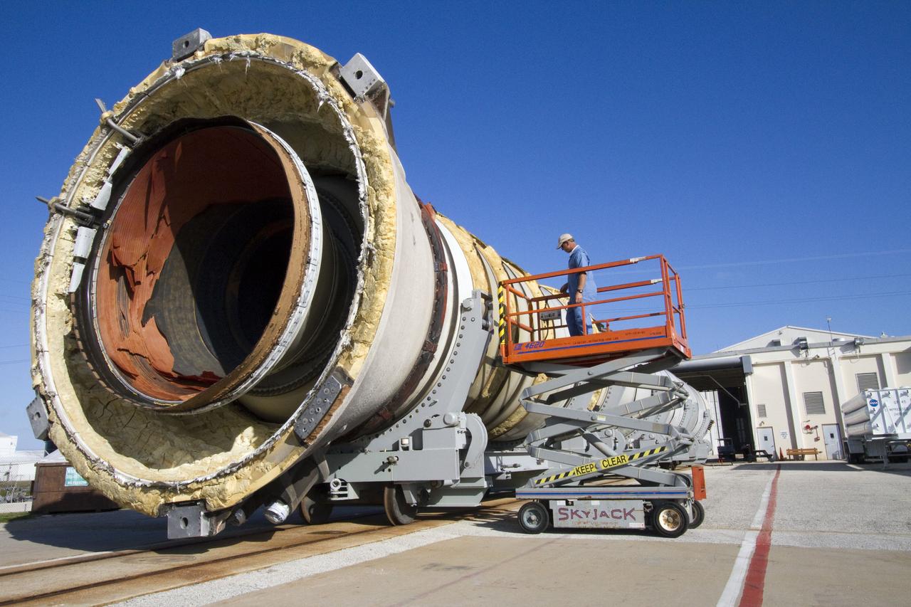 CAPE CANAVERAL, Fla. -- A technician inspects a spent shuttle solid rocket booster outside Hangar AF at Cape Canaveral Air Force Station in Florida. The booster was used during space shuttle Discovery's STS-133 launch from NASA Kennedy Space Center's Launch Pad 39A on Feb. 24. The shuttle’s two solid rocket booster casings and associated flight hardware were recovered in the Atlantic Ocean by retrieval ships Liberty Star and Freedom Star.        The boosters impact the Atlantic about seven minutes after liftoff and the retrieval ships are stationed about 10 miles from the impact area at the time of splashdown.  After the spent segments are processed, they will be transported to Utah, where they will be refurbished and stored, if needed. Photo credit: NASA/Jack Pfaller