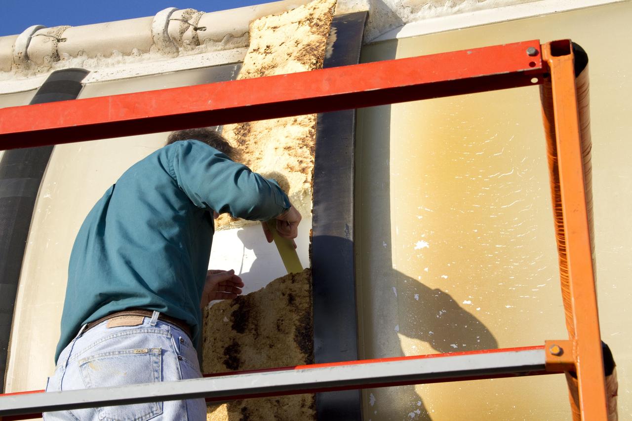 CAPE CANAVERAL, Fla. -- A technician inspects a spent shuttle solid rocket booster outside Hangar AF at Cape Canaveral Air Force Station in Florida. The booster was used during space shuttle Discovery's STS-133 launch from NASA Kennedy Space Center's Launch Pad 39A on Feb. 24. The shuttle’s two solid rocket booster casings and associated flight hardware were recovered in the Atlantic Ocean by retrieval ships Liberty Star and Freedom Star.        The boosters impact the Atlantic about seven minutes after liftoff and the retrieval ships are stationed about 10 miles from the impact area at the time of splashdown.  After the spent segments are processed, they will be transported to Utah, where they will be refurbished and stored, if needed. Photo credit: NASA/Jack Pfaller