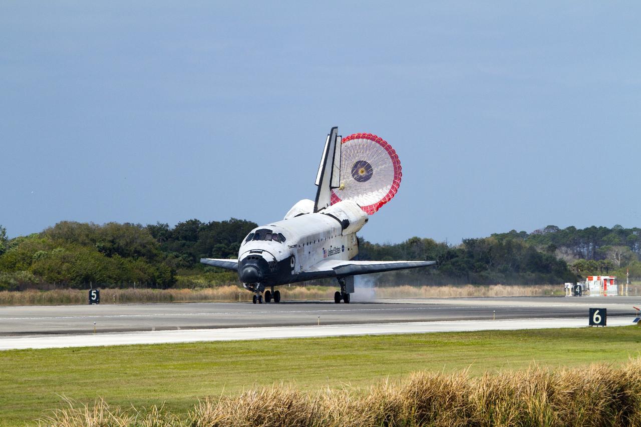 CAPE CANAVERAL, Fla. - With its drag chute unfurled, space shuttle Discovery rolls down Runway 15 at the Shuttle Landing Facility at NASA's Kennedy Space Center in Florida. Landing was at 11:57 a.m. EST, completing the 13-day STS-133 mission to the International Space Station. Main gear touchdown was at 11:57:17 a.m., followed by nose gear touchdown at 11:57:28, and wheelstop at 11:58:14 a.m. On board are Commander Steve Lindsey, Pilot Eric Boe, and Mission Specialists Nicole Stott, Michael Barratt, Alvin Drew and Steve Bowen. Discovery and its six-member crew delivered the Permanent Multipurpose Module, packed with supplies and critical spare parts, as well as Robonaut 2, the dexterous humanoid astronaut helper, to the orbiting outpost. STS-133 was Discovery's 39th and final mission. This was the 133rd Space Shuttle Program mission and the 35th shuttle voyage to the space station. Photo credit: NASA/Jack Pfaller