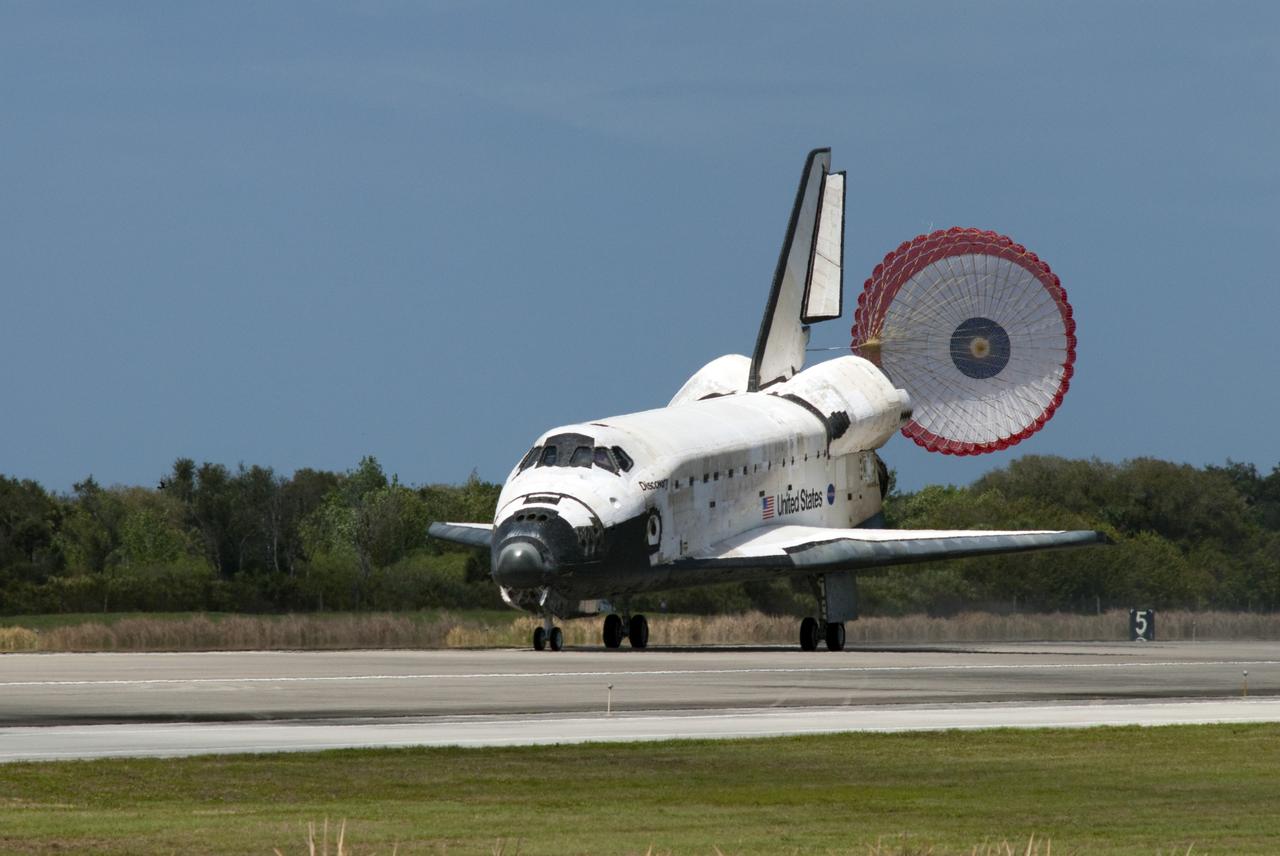 CAPE CANAVERAL, Fla. -- With its drag chute unfurled, space shuttle Discovery rolls down on Runway 15 at the Shuttle Landing Facility at NASA's Kennedy Space Center in Florida. Landing was at 11:57 a.m. EST, completing the 13-day STS-133 mission to the International Space Station. Main gear touchdown was at 11:57:17 a.m., followed by nose gear touchdown at 11:57:28, and wheelstop at 11:58:14 a.m. On board are Commander Steve Lindsey, Pilot Eric Boe, and Mission Specialists Nicole Stott, Michael Barratt, Alvin Drew and Steve Bowen. Discovery and its six-member crew delivered the Permanent Multipurpose Module, packed with supplies and critical spare parts, as well as Robonaut 2, the dexterous humanoid astronaut helper, to the orbiting outpost. STS-133 was Discovery's 39th and final mission. This was the 133rd Space Shuttle Program mission and the 35th shuttle voyage to the space station. Photo credit: NASA/Tim Terry and Mike Kerley