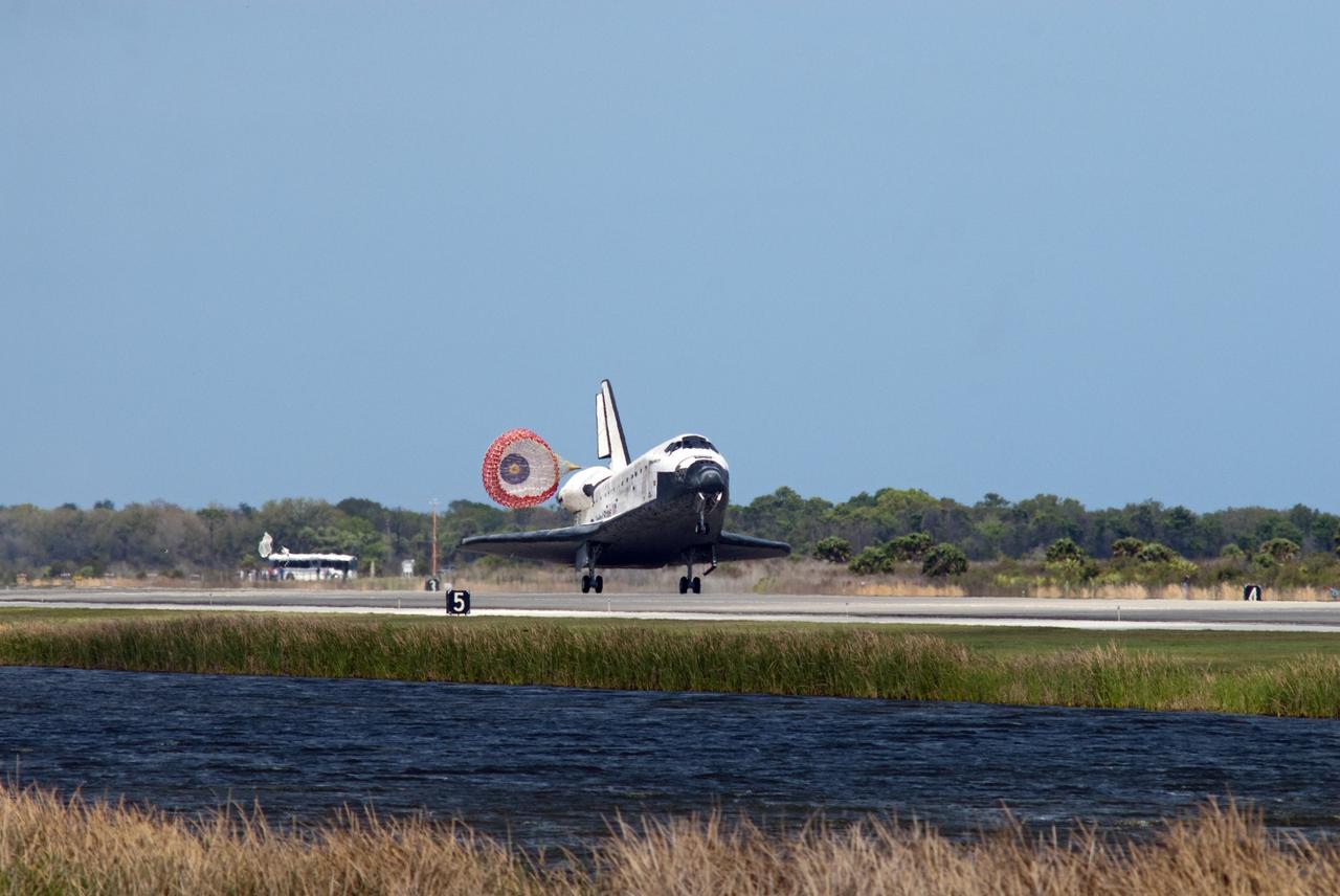 CAPE CANAVERAL, Fla. - Space shuttle Discovery's drag chute deploys on Runway 15 at the Shuttle Landing Facility at NASA's Kennedy Space Center in Florida. Discovery's final return from space completed the 13-day, 5.3-million-mile STS-133 mission.    Main gear touchdown was at 11:57:17 a.m., followed by nose gear touchdown at 11:57:28, and wheelstop at 11:58:14 a.m. On board are Commander Steve Lindsey, Pilot Eric Boe, and Mission Specialists Nicole Stott, Michael Barratt, Alvin Drew and Steve Bowen. Discovery and its six-member crew delivered the Permanent Multipurpose Module, packed with supplies and critical spare parts, as well as Robonaut 2, the dexterous humanoid astronaut helper, to the orbiting outpost. STS-133 was Discovery's 39th and final mission. This was the 133rd Space Shuttle Program mission and the 35th shuttle voyage to the space station. Photo credit: NASA/Tim Powers