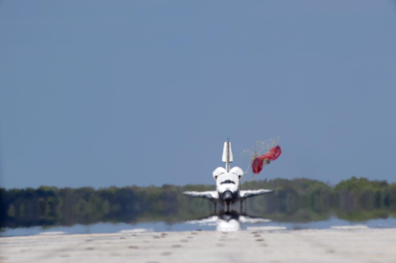 CAPE CANAVERAL, Fla. - Space shuttle Discovery appears to be a mirage as it jettisons its drag chute on Runway 15 at the Shuttle Landing Facility at NASA's Kennedy Space Center in Florida. Discovery's final return from space completed the 13-day, 5.3-million-mile STS-133 mission. Main gear touchdown was at 11:57:17 a.m., followed by nose gear touchdown at 11:57:28, and wheelstop at 11:58:14 a.m. On board are Commander Steve Lindsey, Pilot Eric Boe, and Mission Specialists Nicole Stott, Michael Barratt, Alvin Drew and Steve Bowen.    Discovery and its six-member crew delivered the Permanent Multipurpose Module, packed with supplies and critical spare parts, as well as Robonaut 2, the dexterous humanoid astronaut helper, to the orbiting outpost. STS-133 was Discovery's 39th and final mission. This was the 133rd Space Shuttle Program mission and the 35th shuttle voyage to the space station. Photo credit: NASA/Tony Gray and Tom Farrar