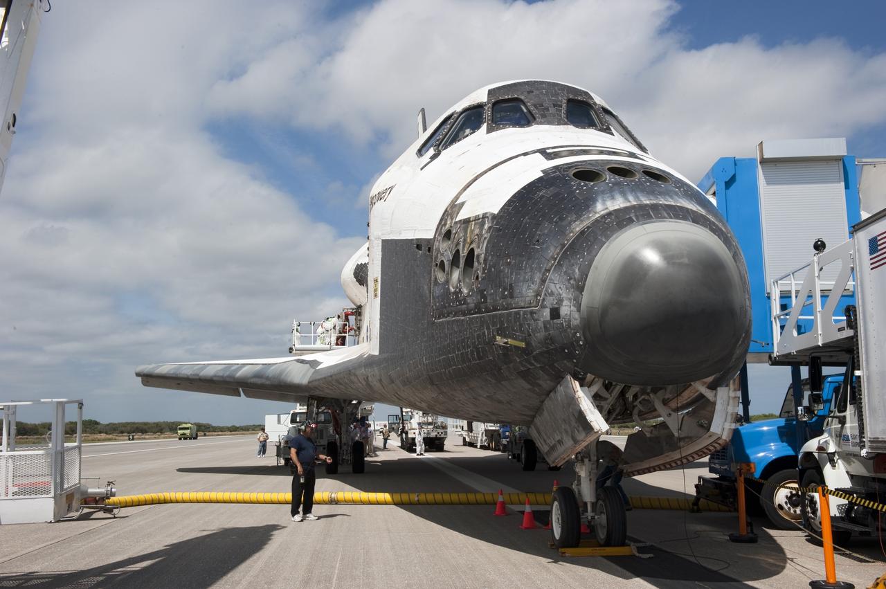 CAPE CANAVERAL, Fla. -- The landing convoy that will make space shuttle Discovery secure for towing to its processing hangar begins to pull up around the spacecraft following wheelstop on the Shuttle Landing Facility's Runway 15 at NASA's Kennedy Space Center in Florida. Discovery's final return from space completed the 13-day, 5.3-million-mile STS-133 mission. Main gear touchdown was at 11:57:17 a.m., followed by nose gear touchdown at 11:57:28, and wheelstop at 11:58:14 a.m.     Discovery and its six-member crew delivered the Permanent Multipurpose Module, packed with supplies and critical spare parts, as well as Robonaut 2, the dexterous humanoid astronaut helper, to the orbiting outpost. STS-133 was Discovery's 39th and final mission. This was the 133rd Space Shuttle Program mission and the 35th shuttle voyage to the space station. Photo credit: NASA/Kim Shiflett