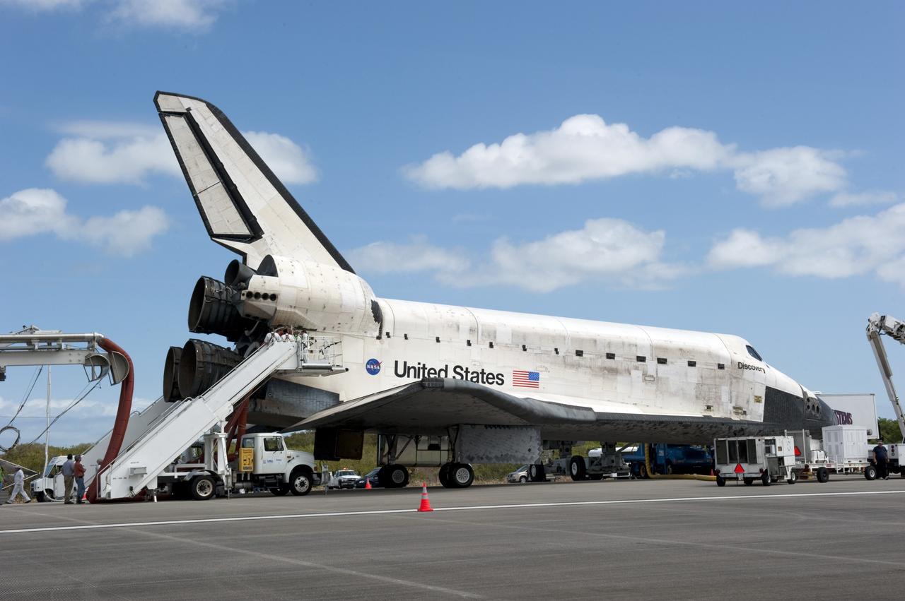 CAPE CANAVERAL, Fla. -- The landing convoy that will make space shuttle Discovery secure for towing to its processing hangar begins to pull up around the spacecraft following wheelstop on the Shuttle Landing Facility's Runway 15 at NASA's Kennedy Space Center in Florida. Discovery's final return from space completed the 13-day, 5.3-million-mile STS-133 mission. Main gear touchdown was at 11:57:17 a.m., followed by nose gear touchdown at 11:57:28, and wheelstop at 11:58:14 a.m.     Discovery and its six-member crew delivered the Permanent Multipurpose Module, packed with supplies and critical spare parts, as well as Robonaut 2, the dexterous humanoid astronaut helper, to the orbiting outpost. STS-133 was Discovery's 39th and final mission. This was the 133rd Space Shuttle Program mission and the 35th shuttle voyage to the space station. Photo credit: NASA/Kim Shiflett